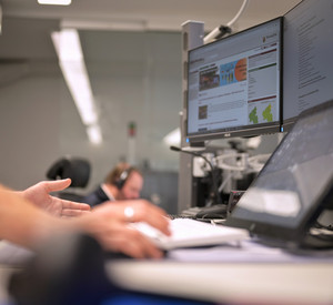 Eine Person arbeitet am Schreibtisch im Lagezentrum Bevölkerungsschutz, auch Bildschirme sind zu sehen.